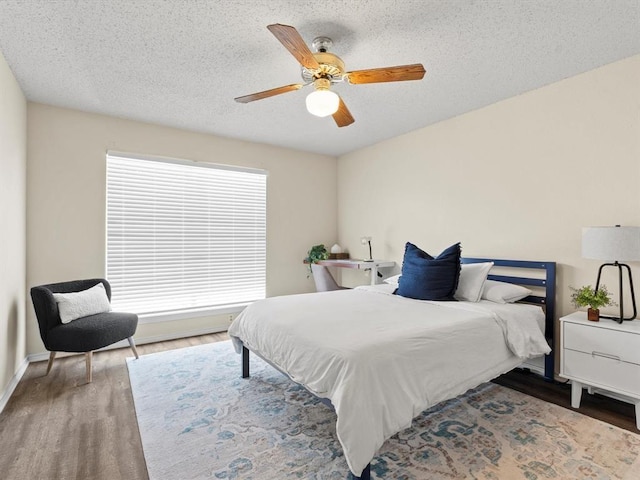 bedroom featuring multiple windows, ceiling fan, and a textured ceiling