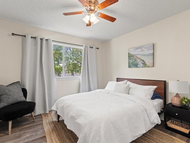 bedroom with wood-type flooring, a textured ceiling, and ceiling fan