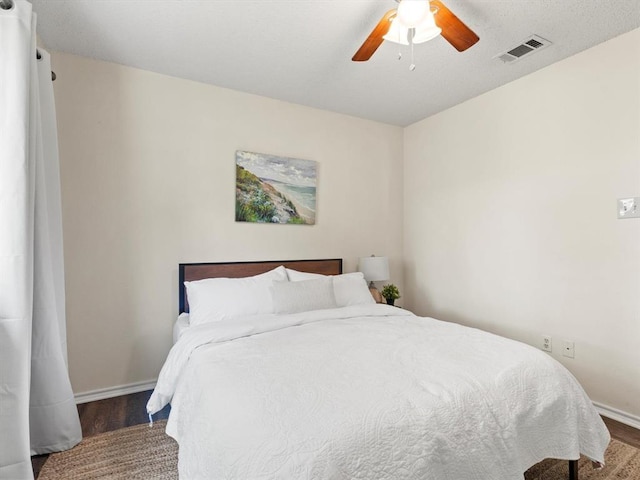 bedroom with dark hardwood / wood-style flooring and ceiling fan