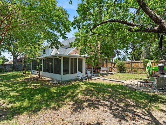 view of yard with a sunroom and an outdoor fire pit