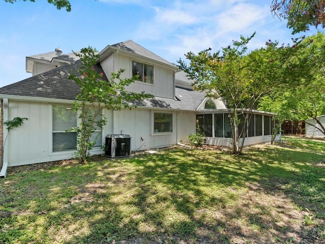 back of property with a yard, central AC unit, and a sunroom