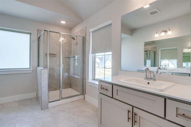 bathroom with vanity, a shower with door, and vaulted ceiling