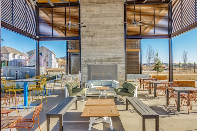 view of patio / terrace featuring ceiling fan and an outdoor living space with a fireplace