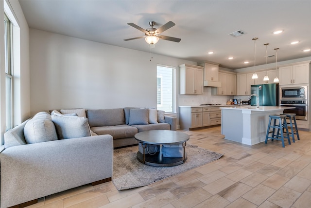 living room featuring ceiling fan and sink