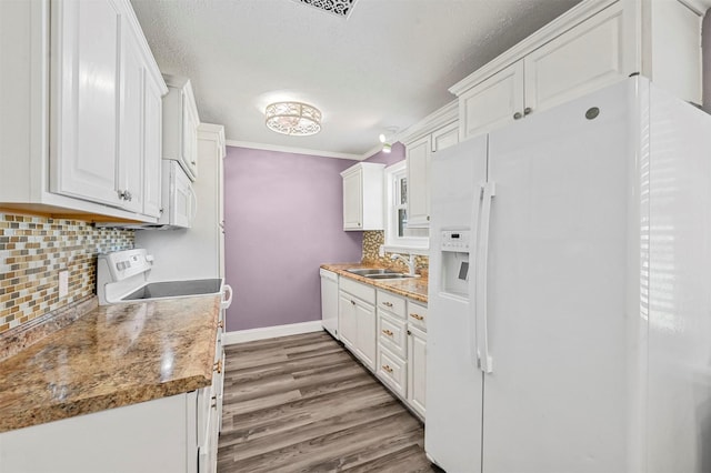 kitchen with sink, white appliances, light stone countertops, and white cabinets