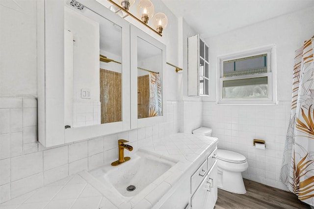 bathroom featuring hardwood / wood-style flooring, tile walls, vanity, a shower with curtain, and toilet