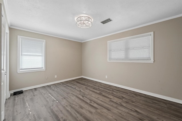 spare room with hardwood / wood-style flooring, ornamental molding, and a textured ceiling