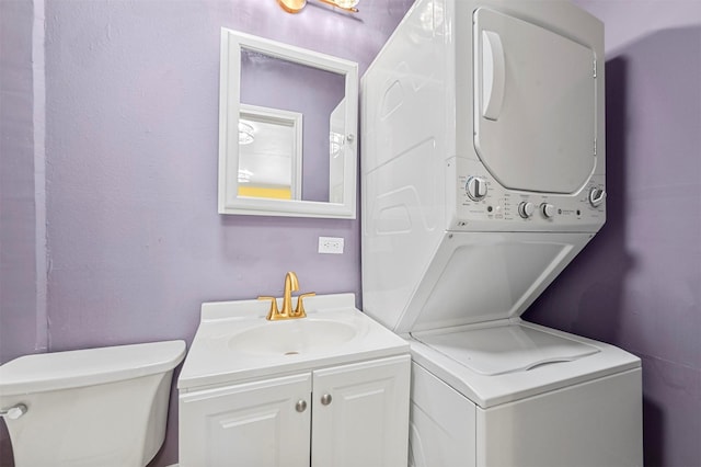 washroom with sink and stacked washer / dryer