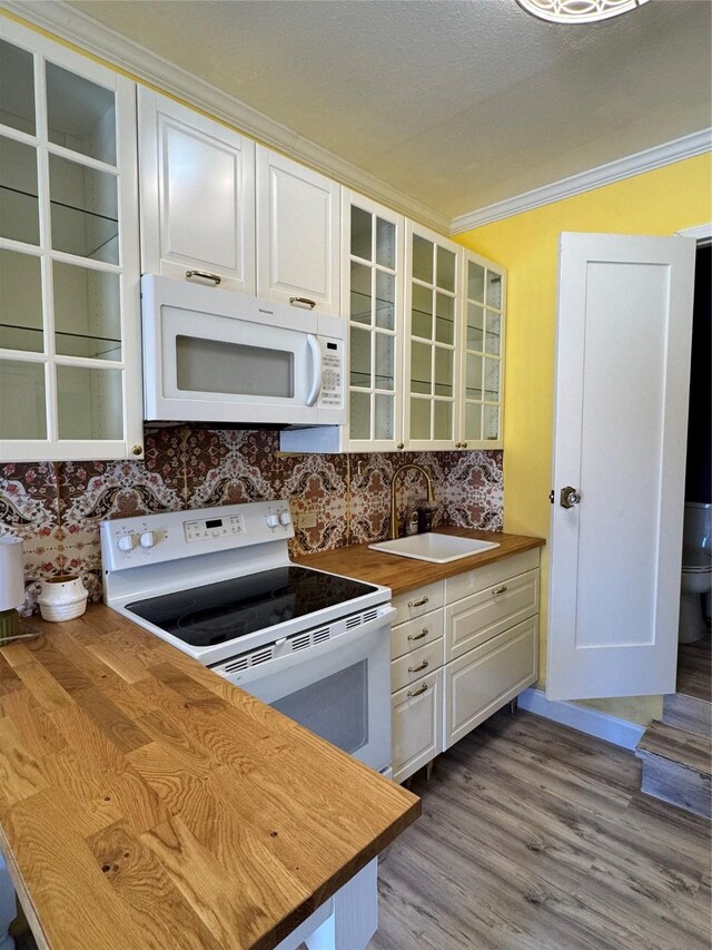 kitchen with white cabinetry, white appliances, wood counters, and sink