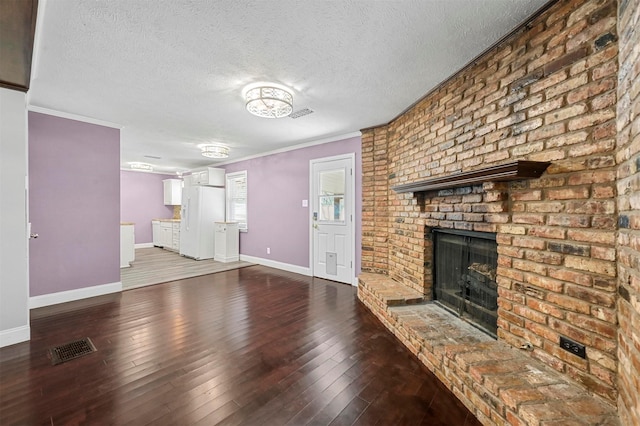 unfurnished living room with hardwood / wood-style floors, a fireplace, ornamental molding, and a textured ceiling