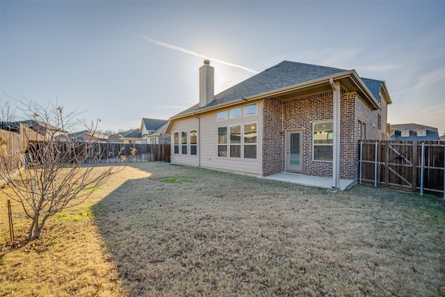 back of house with a yard and a patio