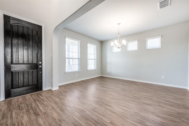 entryway with plenty of natural light, hardwood / wood-style floors, and an inviting chandelier