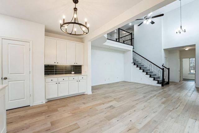 kitchen with white cabinetry, light hardwood / wood-style floors, and tasteful backsplash