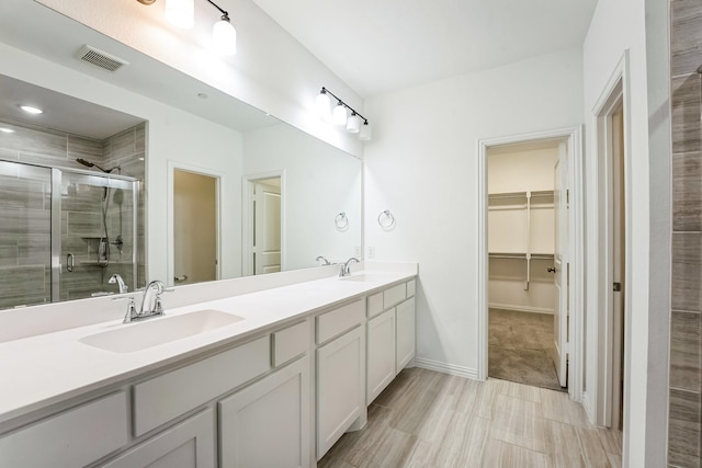 bathroom featuring vanity and a shower with door