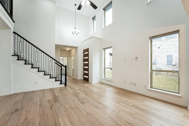 foyer featuring light wood-type flooring, plenty of natural light, and a high ceiling