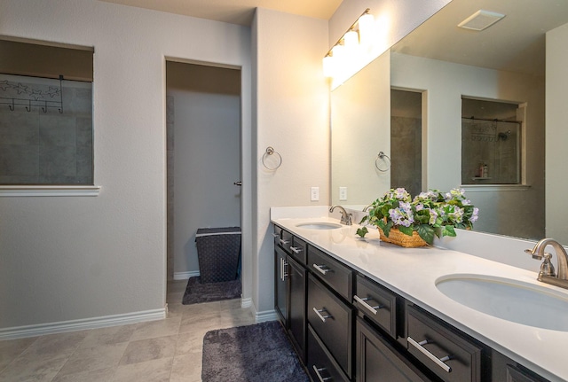 bathroom with a sink, visible vents, baseboards, and double vanity