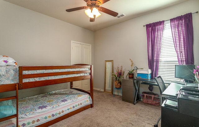 bedroom featuring visible vents, light colored carpet, baseboards, and ceiling fan