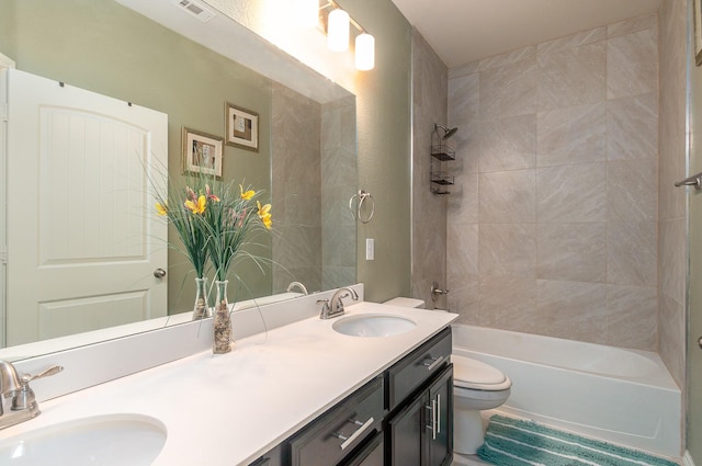 full bathroom featuring vanity, toilet, and tiled shower / bath