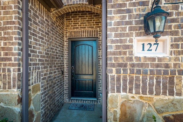 property entrance featuring brick siding