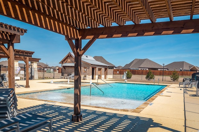 community pool with an outbuilding, fence, a pergola, a storage structure, and a patio area