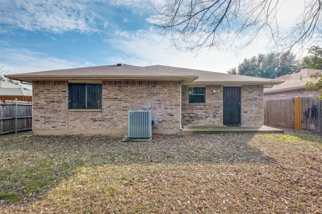 rear view of property featuring central AC, a patio area, and a lawn