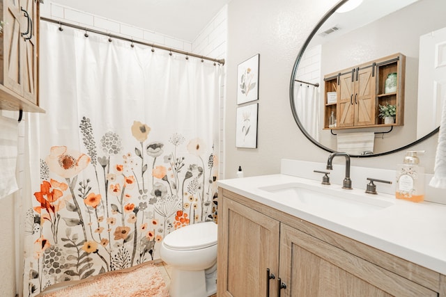 bathroom with vanity, curtained shower, and toilet