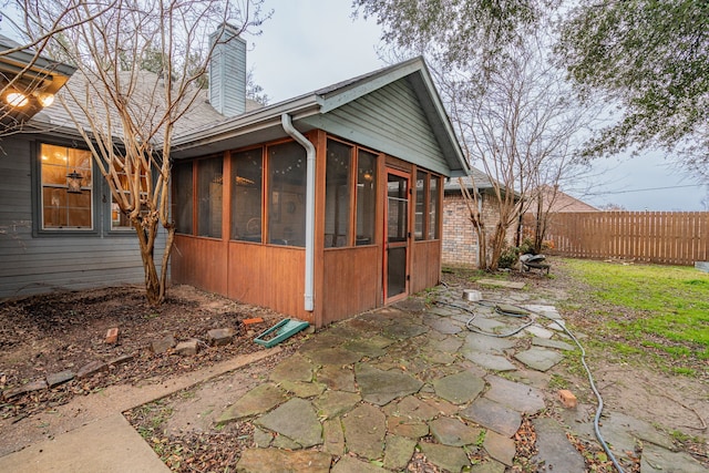 view of property exterior with a patio area and a sunroom