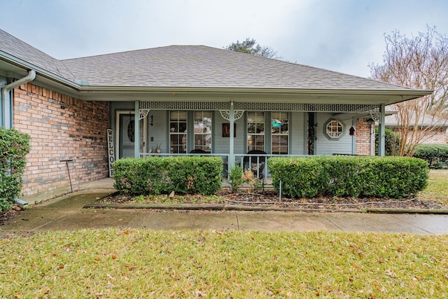 property entrance with a porch and a lawn