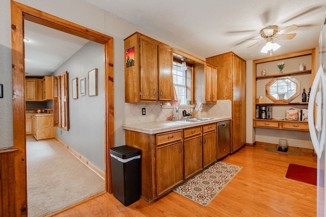 kitchen featuring sink, tasteful backsplash, tile counters, light hardwood / wood-style floors, and stainless steel dishwasher