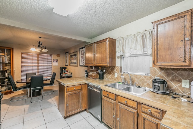 kitchen featuring sink, hanging light fixtures, stainless steel dishwasher, kitchen peninsula, and a textured ceiling