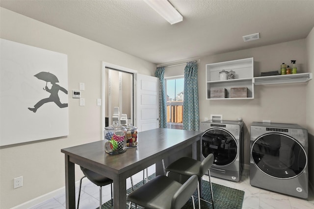 clothes washing area featuring washer and clothes dryer and a textured ceiling