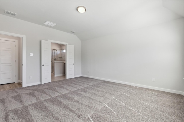 unfurnished bedroom featuring vaulted ceiling and carpet