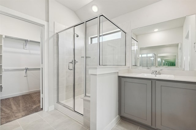 bathroom with tile patterned floors, a shower with door, and vanity