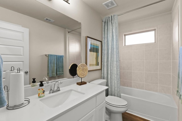 full bathroom with hardwood / wood-style flooring, vanity, shower / bathtub combination with curtain, and toilet