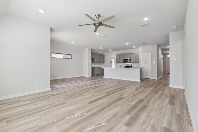 unfurnished living room with ceiling fan and light wood-type flooring