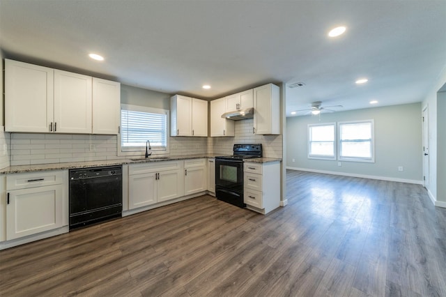 kitchen with white cabinetry, sink, light stone counters, black appliances, and dark wood-type flooring