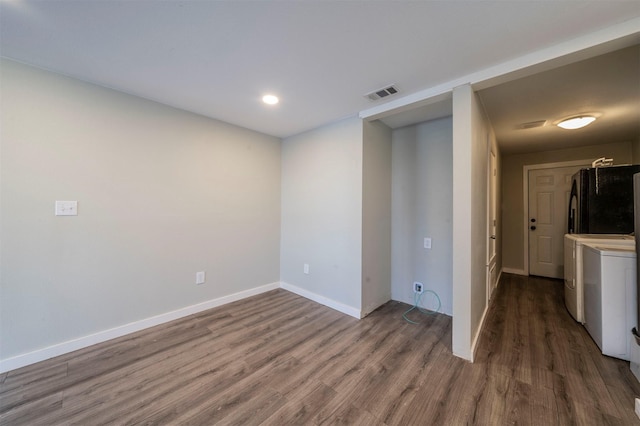 spare room featuring independent washer and dryer and dark hardwood / wood-style floors