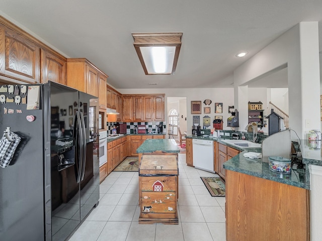 kitchen featuring sink, white appliances, a center island, and light tile patterned flooring