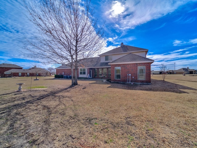 rear view of house featuring a yard