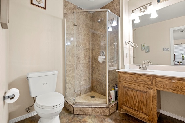 bathroom featuring a shower with door, vanity, and toilet