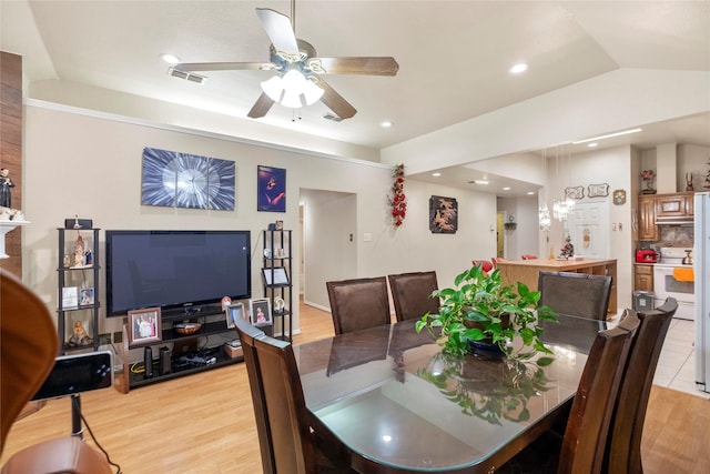 dining space featuring vaulted ceiling, ceiling fan, and light hardwood / wood-style flooring