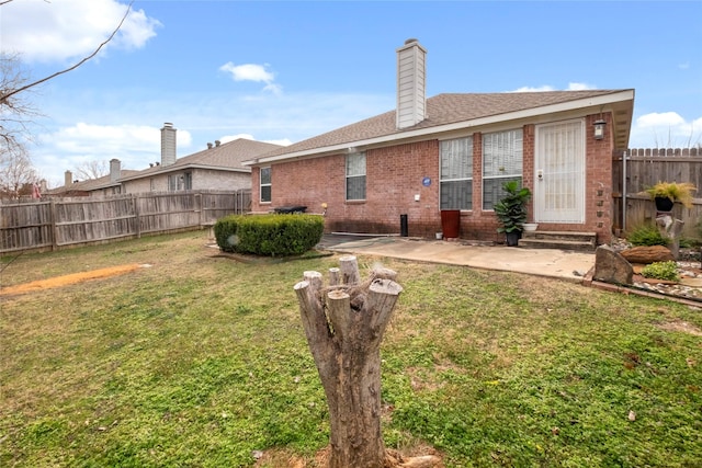 rear view of property featuring a lawn and a patio area