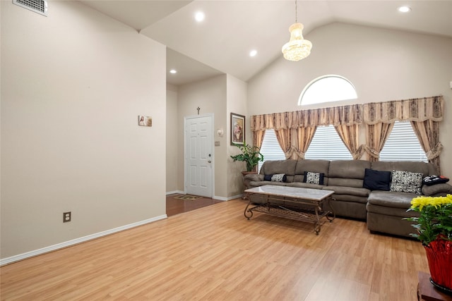 living room with high vaulted ceiling and light hardwood / wood-style floors