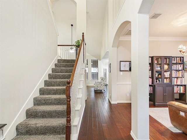 stairs featuring hardwood / wood-style flooring and ornamental molding