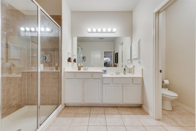 bathroom featuring tile patterned flooring, vanity, an enclosed shower, and toilet