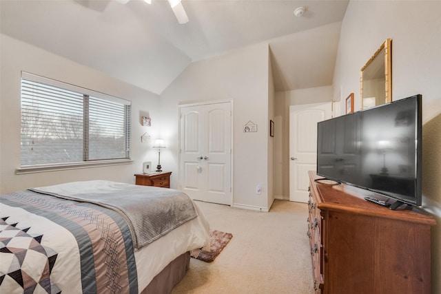 bedroom featuring lofted ceiling, light carpet, ceiling fan, and a closet