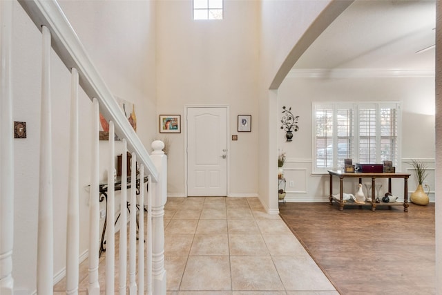 entrance foyer featuring ornamental molding and light tile patterned flooring