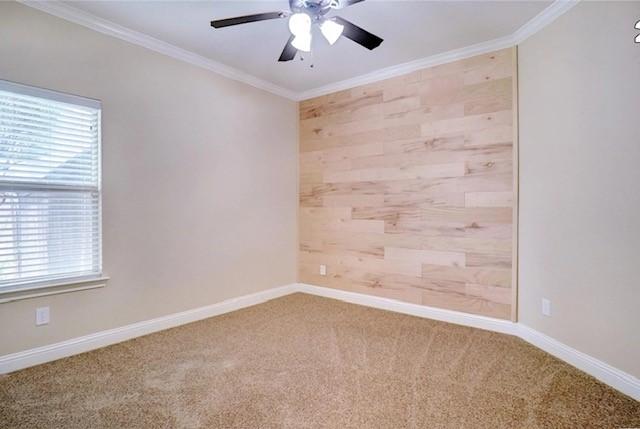 unfurnished room featuring carpet floors, ornamental molding, baseboards, and ceiling fan