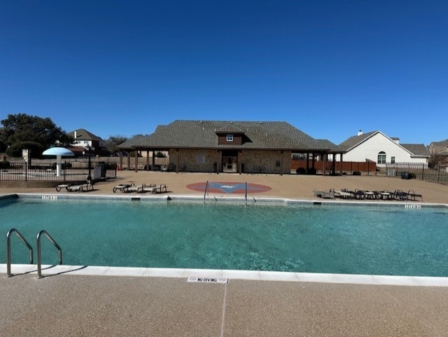 community pool featuring fence and a patio