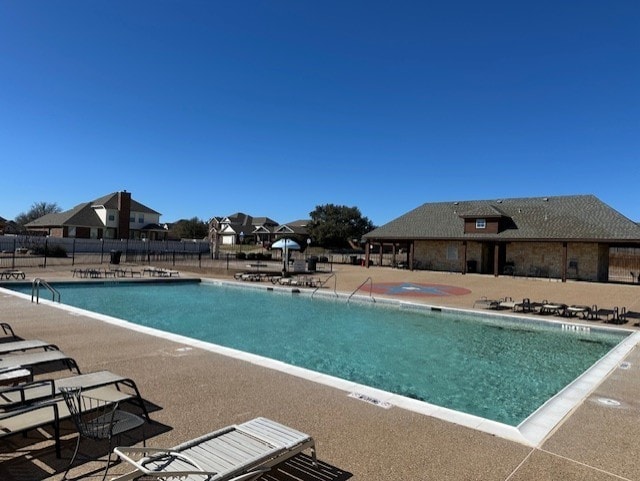 community pool featuring fence and a patio